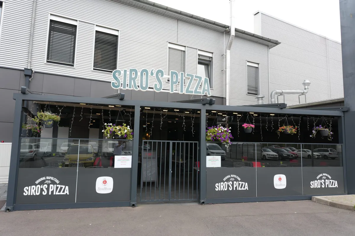 Außenansicht der Osteria Siros mit blumengeschmückter Terrasse