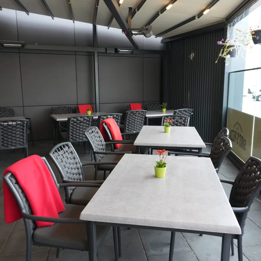 Langer Terrassentisch mit roten Akzentstühlen
