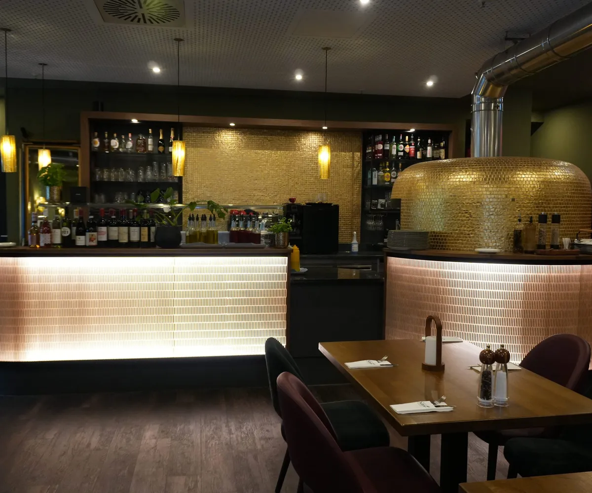 Panorama von Bar und goldenem Steinofen der Osteria Siros