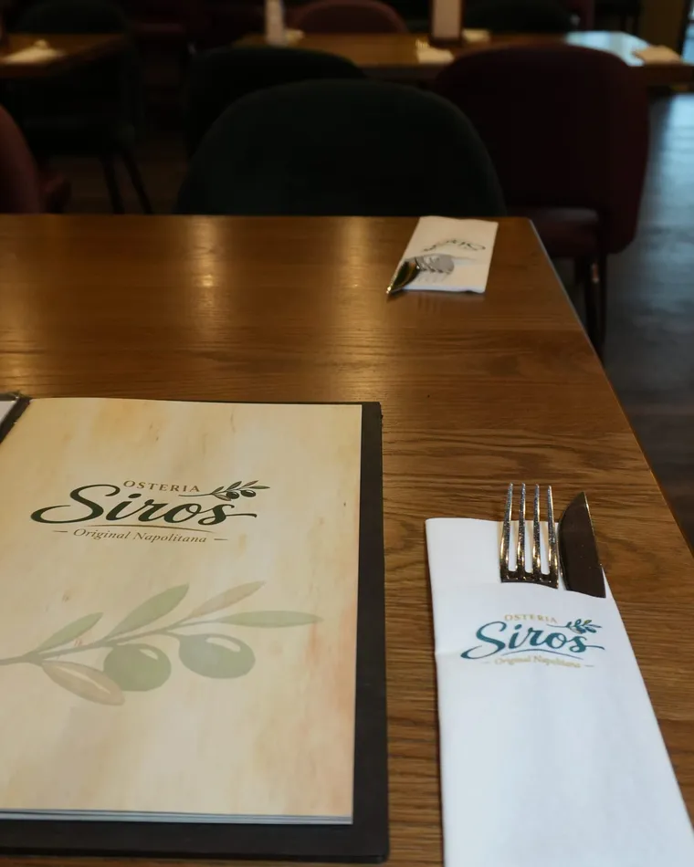 Siro’s-Speisekarte und Besteck auf einem Holztisch